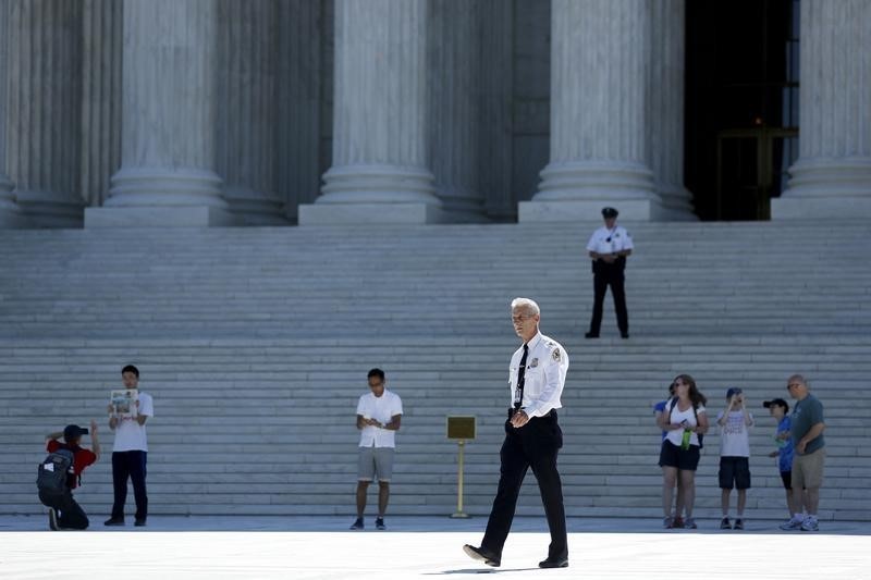 © Reuters. A police officer patrols the plaza in front of the U.S. Supreme Court building in Washington