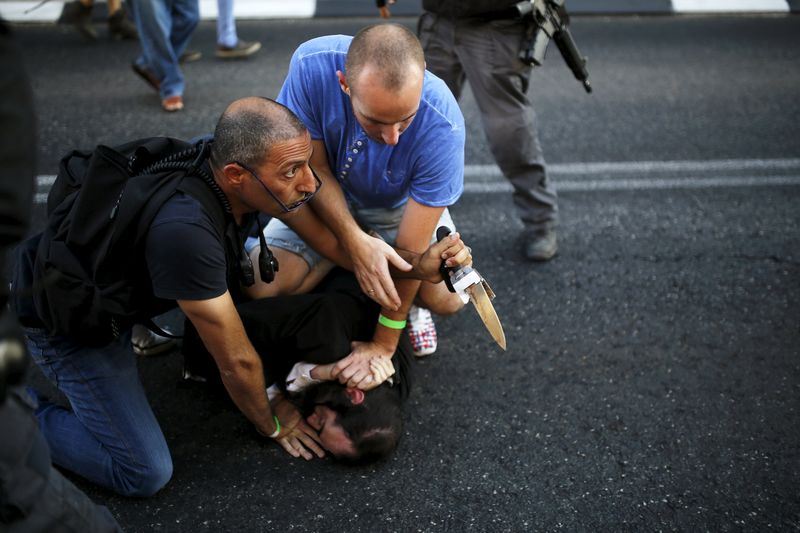 © Reuters. Pessoas desarmam judeu ortodoxo após ataque à Parada Gay em Jerusalém 