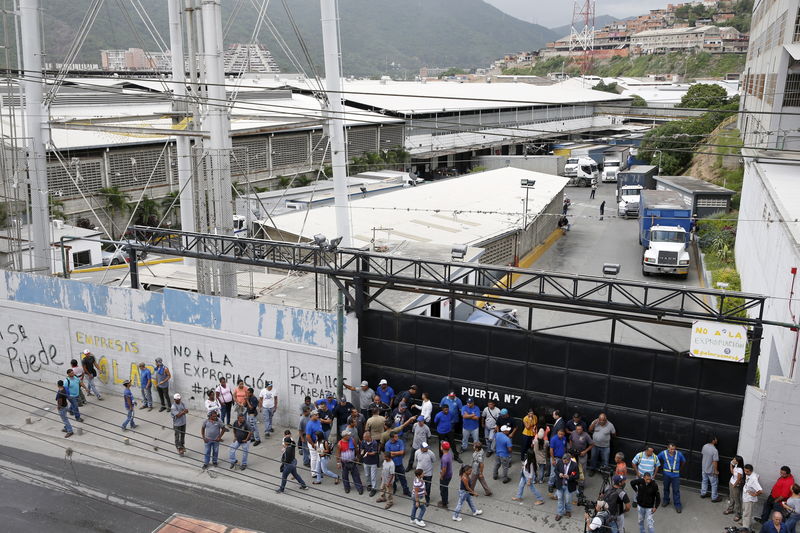 © Reuters. Pessoas se reúnem na porta de depósito usado pela Empresas Polar em Caracas 