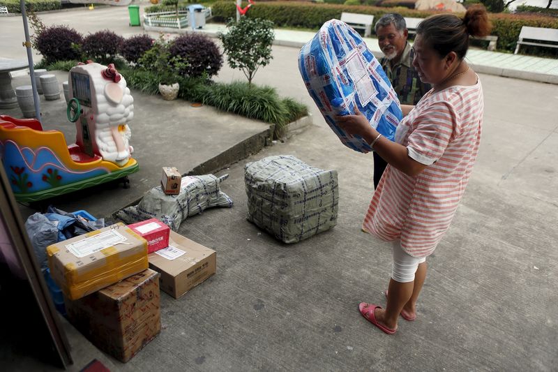 © Reuters. Customer checks on a parcel at an Alibaba rural service centre in Jinjia Village, Tonglu