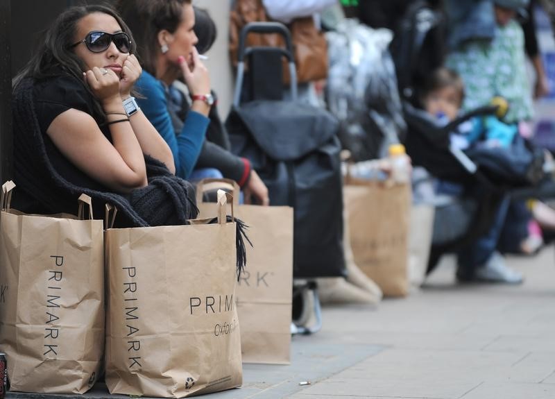 © Reuters. Shoppers sit outside a retail store in Oxford Street in central London