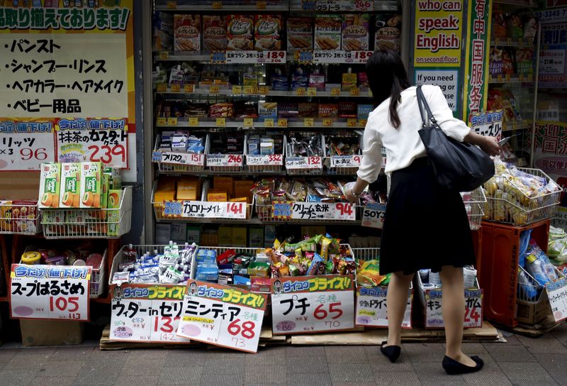 © Reuters. A shopper looks at items outside a discount drug store at a shopping district in Tokyo