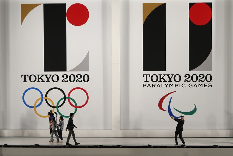 © Reuters. Murofushi, Olympic gold medal-winning hammer thrower and Tokyo 2020 Sports Director, poses for pictures in front of Tokyo 2020 Olympic and Paralympic games emblems after an unveiling event at Tokyo Metropolitan Government Building in Tokyo