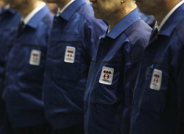 © Reuters. Logos of Tokyo Electric Power Co., operator of the tsunami-crippled Fukushima Daiichi nuclear plant, are seen on company uniforms as employees listen to a video speech by company president Hirose after taking part in a moment of silence in Tokyo
