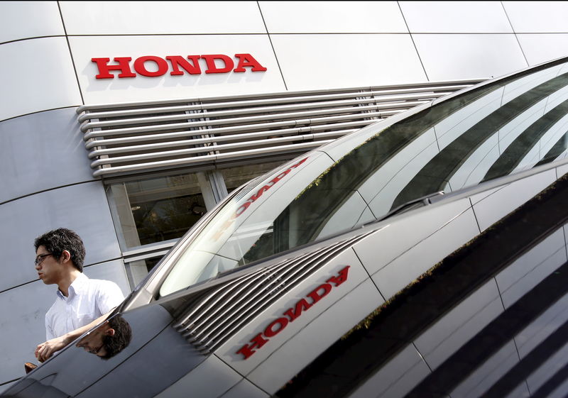 © Reuters. A man walks past a Honda Motor Co's car displayed outside a showroom at the company's headquarters in Tokyo