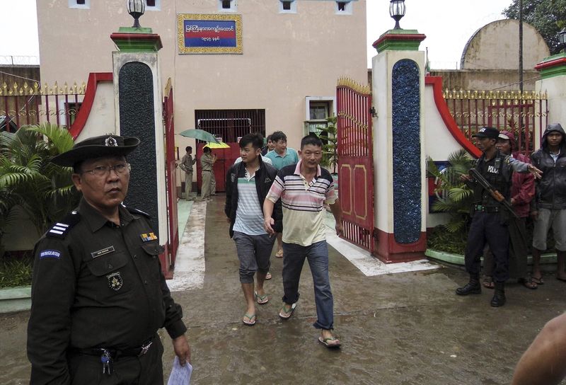 © Reuters. Chinese nationals, who were jailed for illegal logging, walk out of Myitkyina prison after being released during an amnesty in Myitkyina