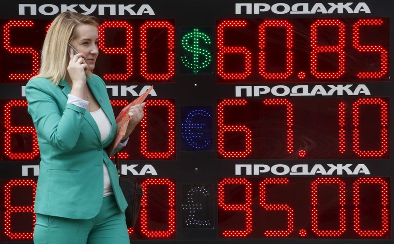 © Reuters. Женщина у табло с курсами обмена валюты в Москве