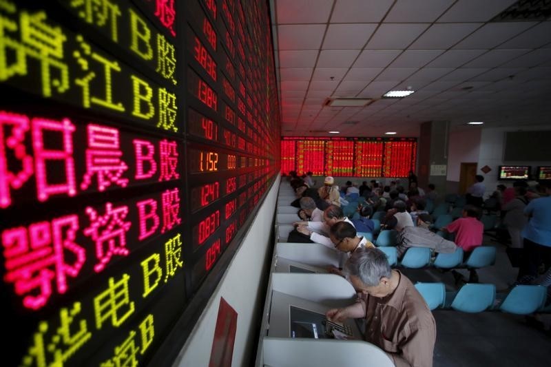 © Reuters. Investors look at computer screens showing stock information at a brokerage house in Shanghai