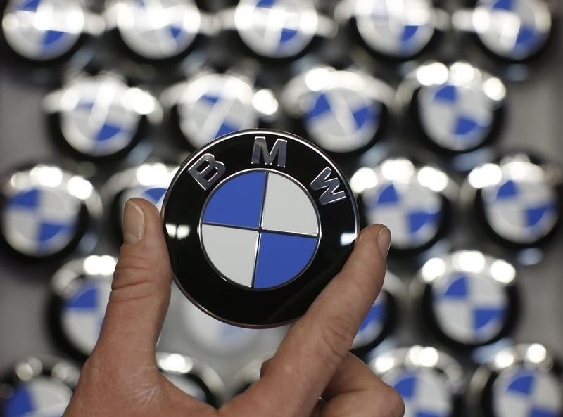 © Reuters. An employee holds BMW logo on production line of BMW C evolution electric maxi-scooter at BMW motorcycle plant in Berlin