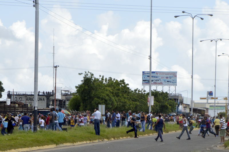 © Reuters. Venezuelanos carregam produtos saqueados de um supermercado em San Felix