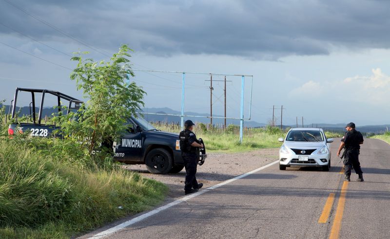 © Reuters. Policiais fazem controle no tráfego numa rodovia que leva à cidade de Badiraguato