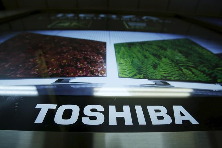 © Reuters. A logo of Toshiba Corp is seen next to an advertisement board for its Regza television in Tokyo