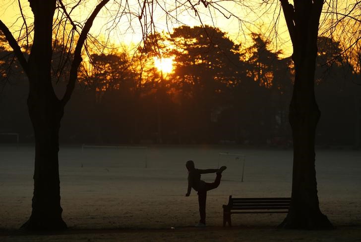 © Reuters. Una mujer hace ejercicio en el amanecer en Victoria Park, en Leicester, Inglaterra
