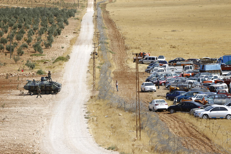 © Reuters. Turkish military vehicle stands next to Turkish-Syrian border as Kurdish Syrian refugees gather near town of Suruc