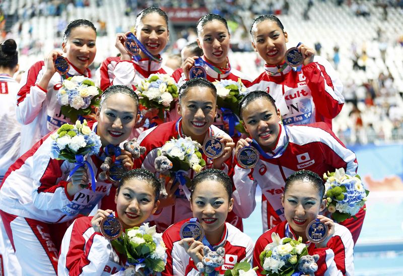 © Reuters. Members of team Japan pose with their bronze medals after the women's synchronised swimming free routine combination final at the Aquatics World Championships in Kazan
