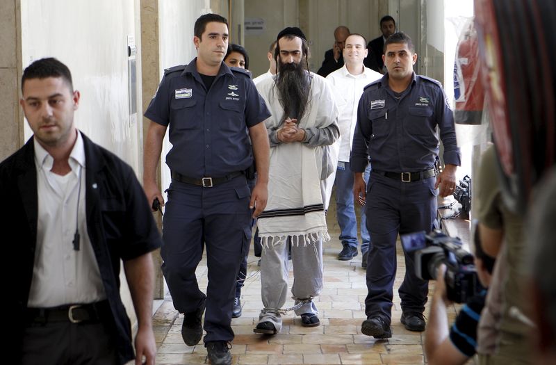 © Reuters. Yishai Schlissel is escorted by security personnel at the Jerusalem Magistrates Court 