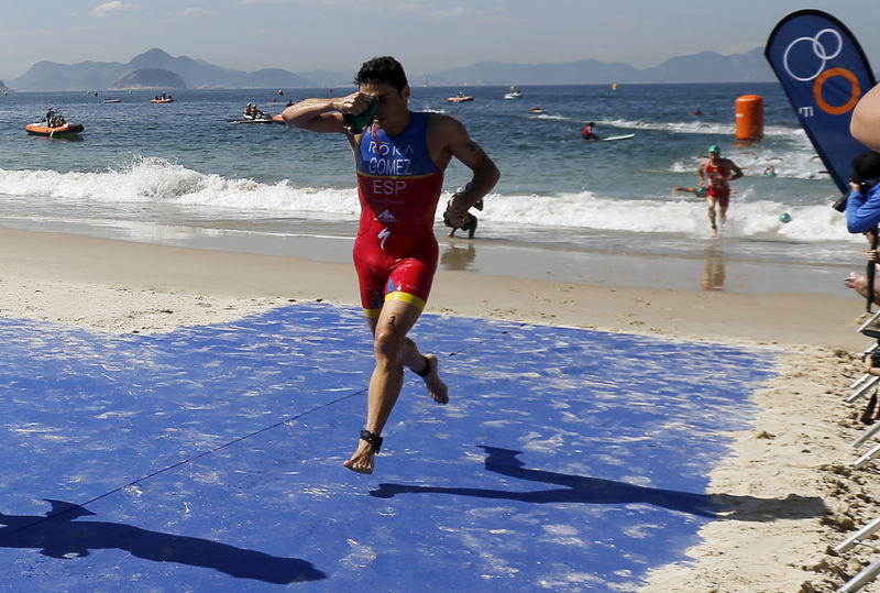 © Reuters. Noya of Spain  runs after the swimming leg of the men's triathlon at the ITU World Olympic Qualification event on Copacabana beach in Rio de Janeiro