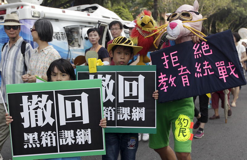 © Reuters. Activists march on the street during a protest in front of the Ministry of Education in Taipei