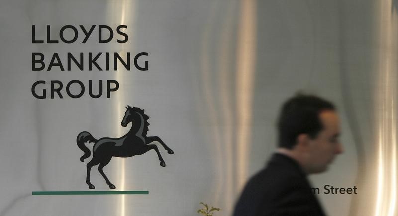 © Reuters. A man walks past a sign outside Lloyds Banking Group's headquarters in the City of London