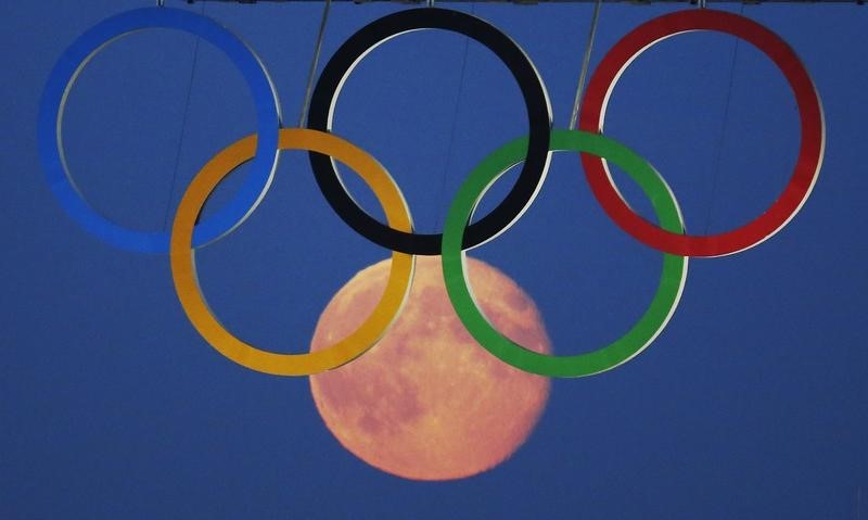 © Reuters. The full moon rises through the Olympic Rings hanging beneath Tower Bridge during the London 2012 Olympic Games