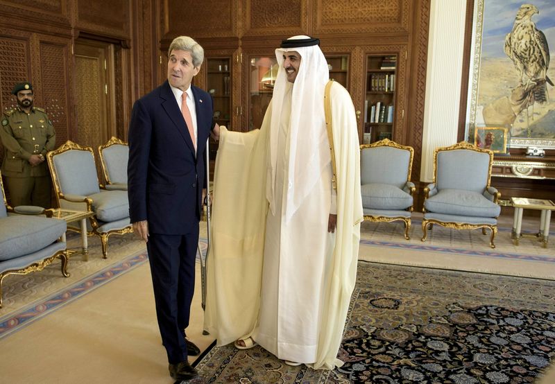 © Reuters. U.S. Secretary of State Kerry talks with Qatar's Emir Sheikh Tamim before their meeting at the Diwan Palace in Doha