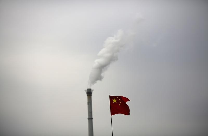 © Reuters. China's national flag is seen in front of a chimney of a cogeneration plant in Beijing