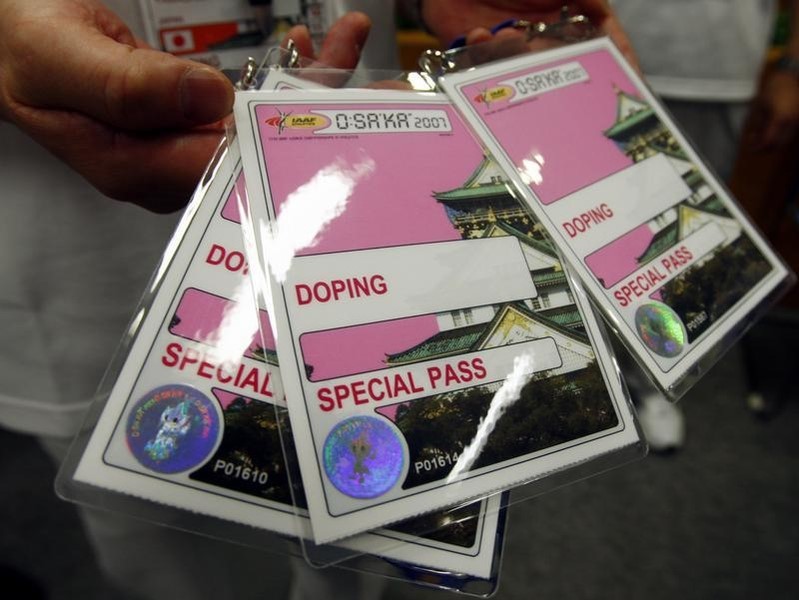 © Reuters. Volunteer with IAAF's local organizing committee displays credential given to athletes who are selected for drug testing in anti-doping offices in Osaka