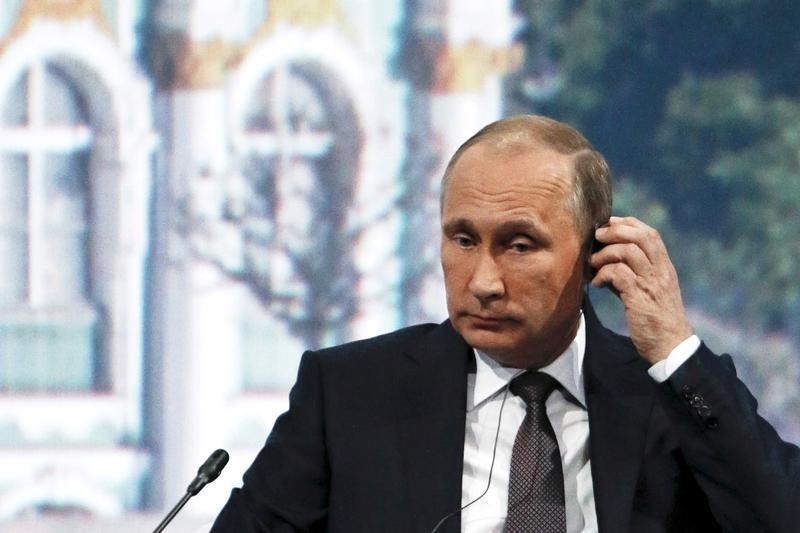 © Reuters. Russian President Putin adjusts his earphones during a session of the SPIEF 2015 in St. Petersburg