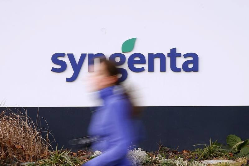 © Reuters. A woman runs past Swiss agrochemicals maker Syngenta's logo in front of the company's headquarters in Basel