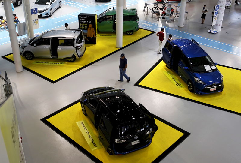 © Reuters. A visitor walks between Toyota Motor Corp's cars displayed at the company's showroom in Tokyo