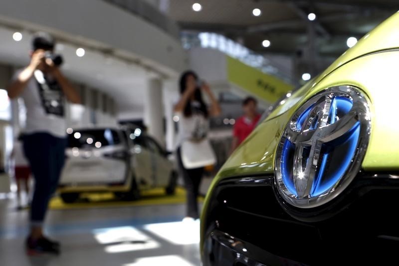 © Reuters. Visitors take pictures of Toyota Motor Corp's cars displayed at the company's showroom in Tokyo