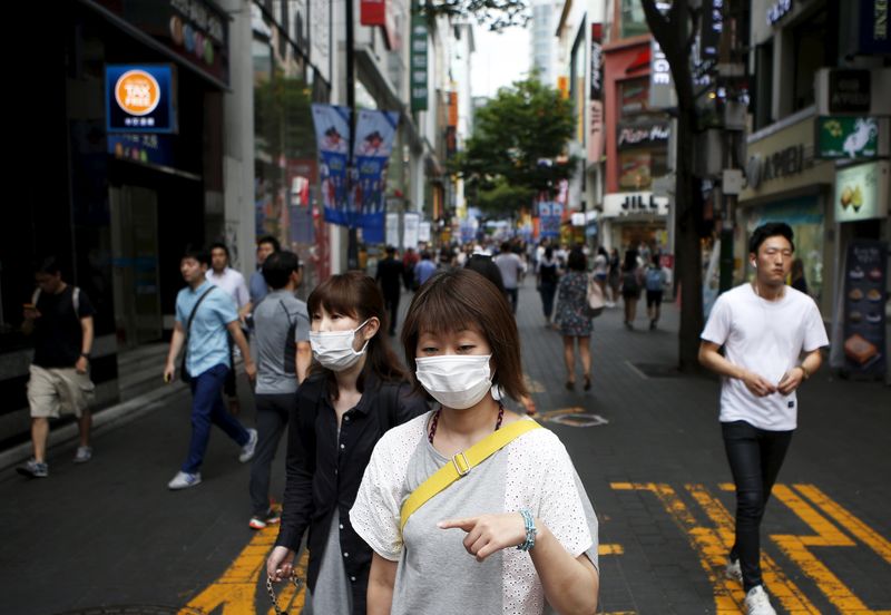 © Reuters. Women wearing masks to prevent contracting Middle East Respiratory Syndrome (MERS) walk at Myeongdong shopping district in central Seoul