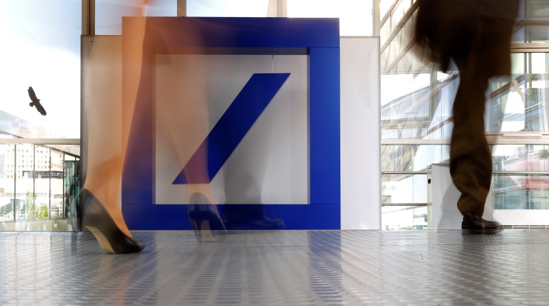 © Reuters. People walk past a Deutsche Bank logo ahead the banks annual general meeting in Frankfurt