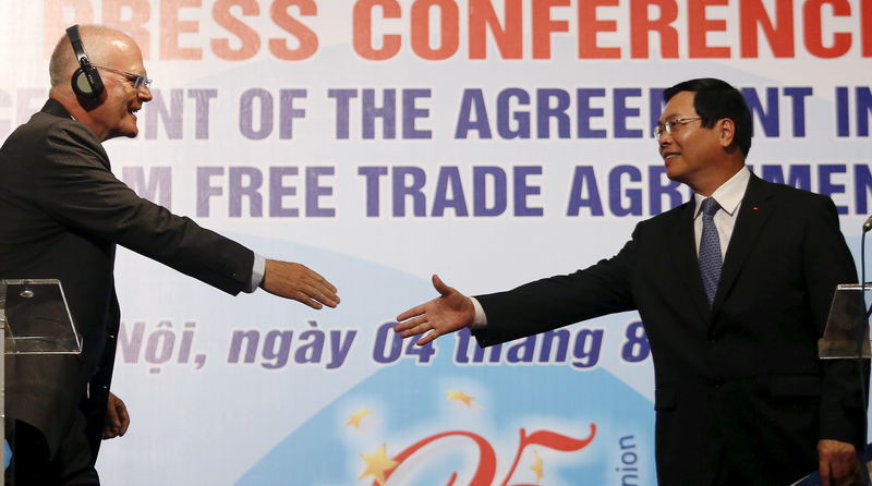 © Reuters. Vietnam's Trade Minister Vu Huy Hoang reaches out to shake hands with EU's Ambassador - Head of Delegation to Vietnam Jessen after a news conference in Hanoi