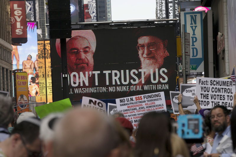 © Reuters. An image of Iranian leaders is projected on a giant screen in front of demonstrators  during a rally apposing the nuclear deal with Iran in Times Square in the Manhattan borough of New York