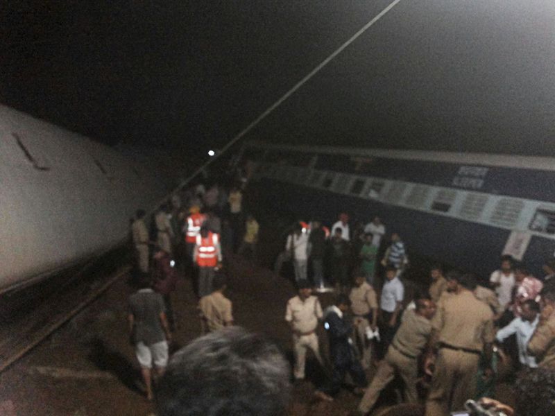 © Reuters. Police and members of the rescue operation stand at the site of a train derailment near Harda, Madhya Pradesh in this handout 