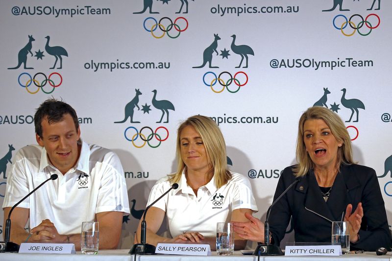© Reuters. Australia's Olympic 100 metres hurdles champion Sally Pearson and basketballer Joe Ingles react as they listen to Australia's chef de mission Kitty Chiller as she speaks during a media conference in Sydney, Australia