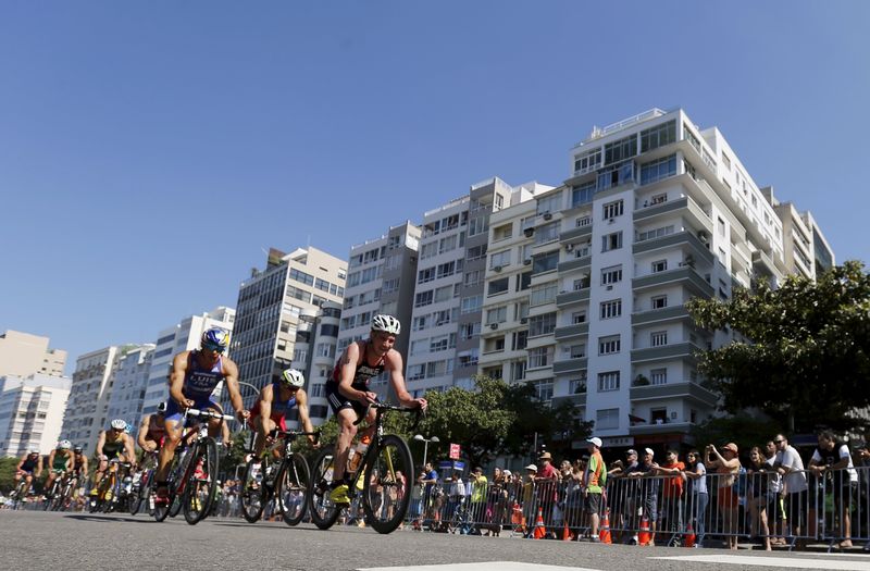 © Reuters. Ciclistas pedalam na orla de Copacabana durante evento-teste do triatlo para os Jogos de 2016