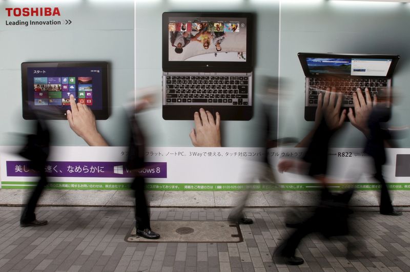 © Reuters. File photo of passersby walking past an advertisement for Toshiba Corp. outside an electronic store in Tokyo
