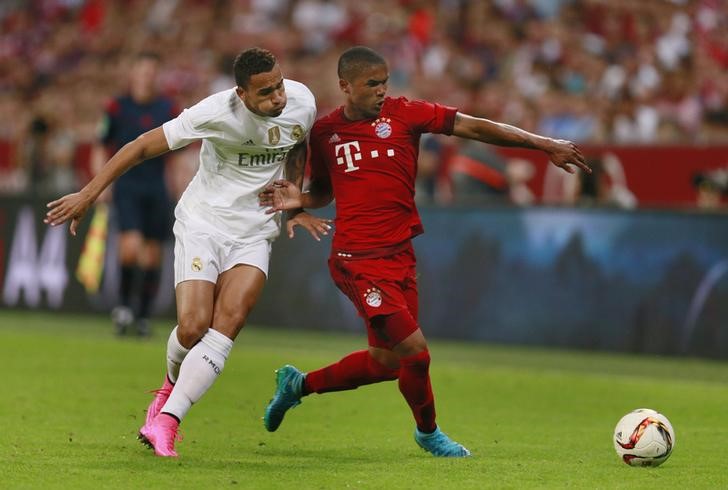 © Reuters. Douglas Costa (direita), do Bayern de Munique, em disputa de bola com Danilo, do Real Madrid