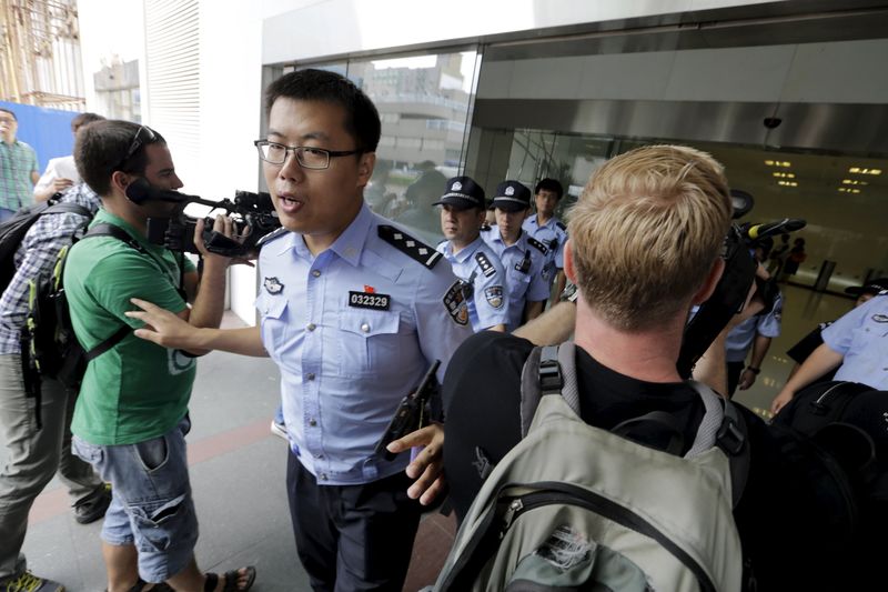 © Reuters. Police keep the media out of the lobby where relatives of passengers who were aboard Malaysia Airlines flight MH370 try to express their demands to Malaysia Airlines at its Beijing office 