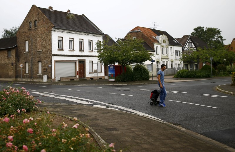 © Reuters. Alban, a 27-year old refugee from Albania walks through the empty streets of the village of Kerpen Manheim on their way towards the bus station in Manheim