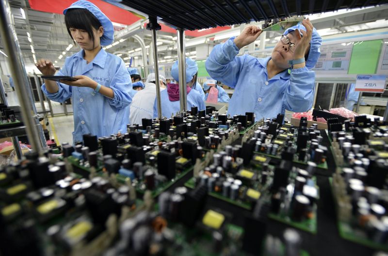 © Reuters. Employees work at a production line of electronic panels at a factory of FiberHome Technologies Group, in Wuhan