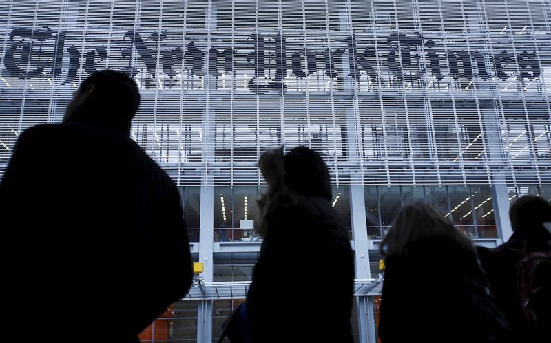 © Reuters. People stand across the street from the New York Times head office in New York