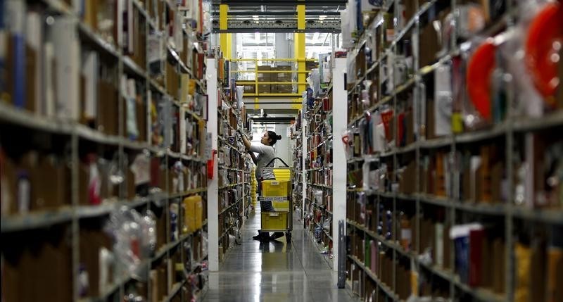 © Reuters. Worker gathers items for delivery from the warehouse floor at Amazon's distribution center in Phoenix