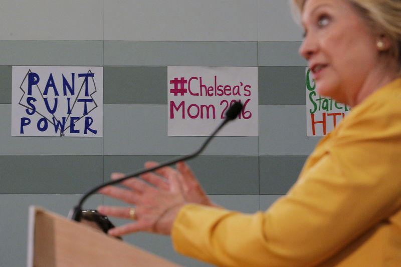 © Reuters. Democratic presidential candidate Hillary Clinton answers a reporter's question in front of a sign reading "Pant Suit Power" following a town hall campaign stop in Nashua