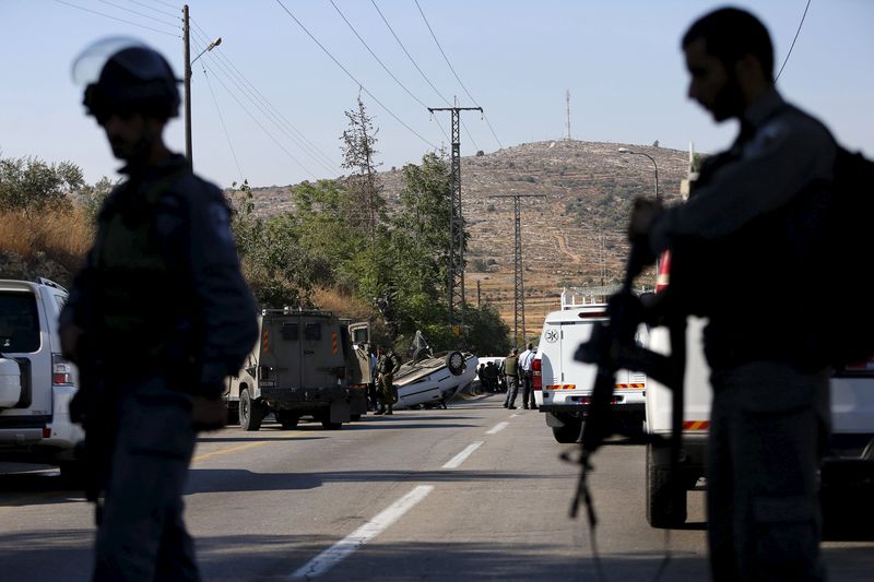 © Reuters. Israeli policemen stand guard at the scene of a ramming attack near the West Bank village of Sinjil near Ramallah 