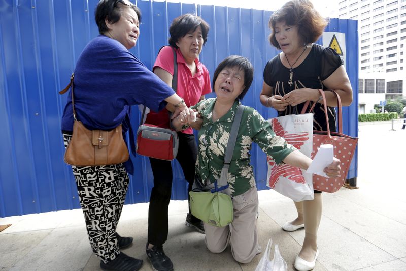 © Reuters. Parentes de passageiros do voo MH370 choram em Pequim