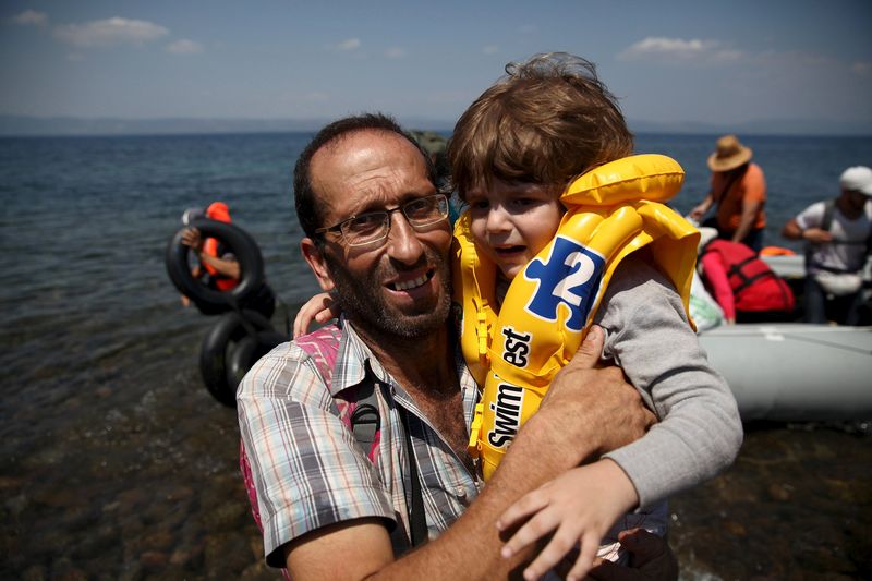 © Reuters. تحقيق-لاجئون يهللون ويسجدون ويعانقون الغرباء بعد وصولهم اليونان