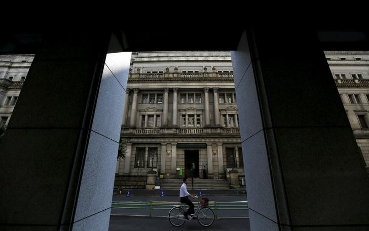 © Reuters. Man cycles in front of the BOJ building in Tokyo